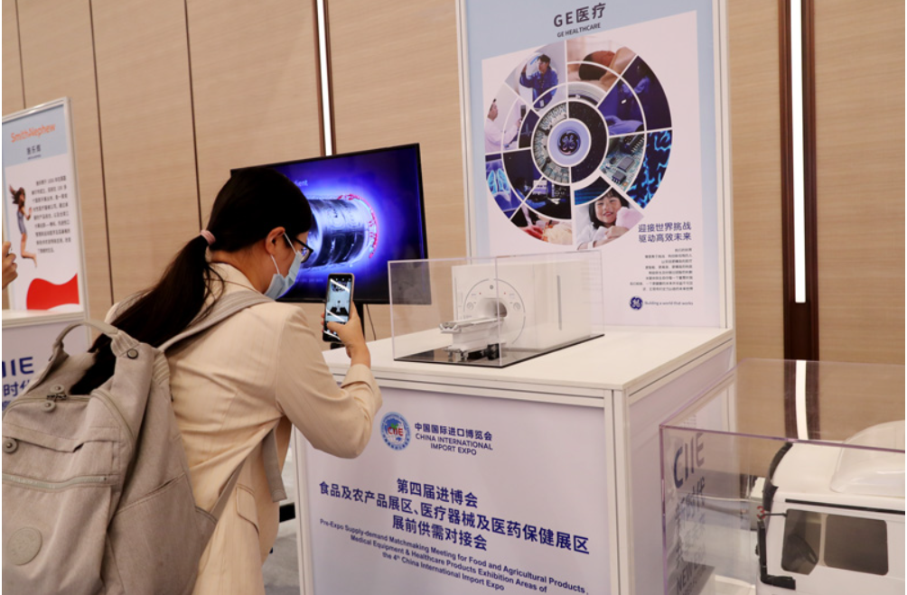 第四屆進(jìn)博會食品及農(nóng)產(chǎn)品展區(qū)、醫(yī)療器械及醫(yī)藥保健展區(qū)展前供需對接會的參會嘉賓用手機(jī)拍攝參展企業(yè)的展品模型